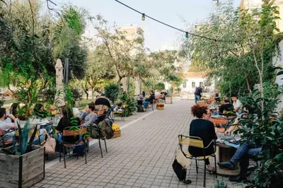 a group of people sitting at tables in a garden at Academy Elegant Apartment #101 in Athens
