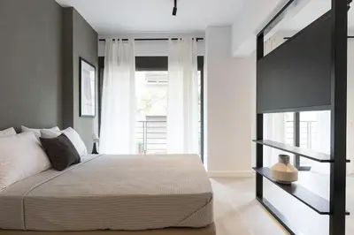 a bedroom with a bed and a large window at Academy Elegant Apartment #101 in Athens