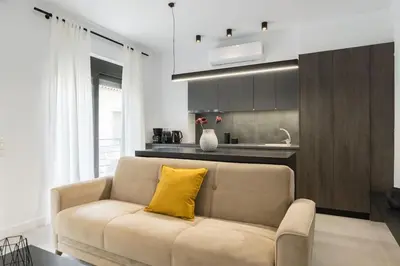 a living room with a yellow pillow on a couch at Academy Elegant Apartment #101 in Athens