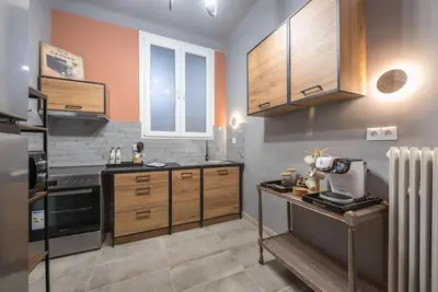 a kitchen with wooden cabinets and a counter top at Rest sleep repeat by museum in a modern Victorian way in Athens
