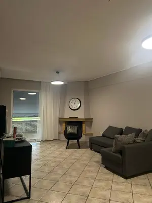 a living room with a couch and a clock on the wall at anastasis house in Athens