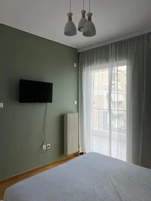 a bedroom with a bed and a television on the wall at anastasis house in Athens
