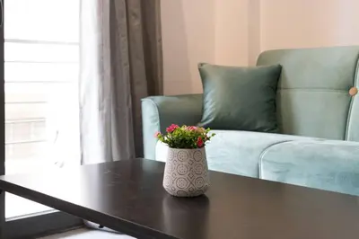 a vase with flowers sitting on a table in a living room at Academy Elegant Apartment #102 in Athens