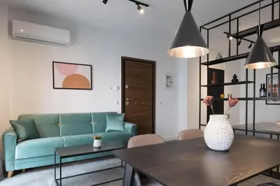 a living room with a blue couch and a table at Academy Elegant Apartment #102 in Athens