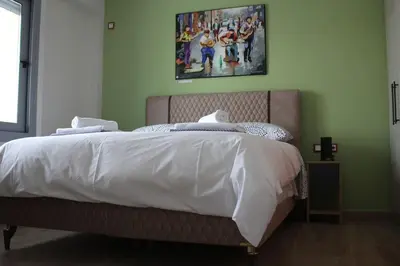 a bed in a bedroom with a picture on the wall at Agnes apartment Filopappou in Athens