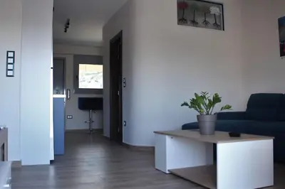 a living room with a blue couch and a table at Agnes apartment Filopappou in Athens