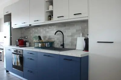a kitchen with blue cabinets and a sink at Agnes apartment Filopappou in Athens
