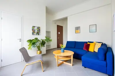 a living room with a blue couch and a table at Best spot apartment in Athens in Athens