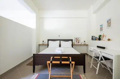 a bedroom with a bed and a desk and a chair at Best spot apartment in Athens in Athens