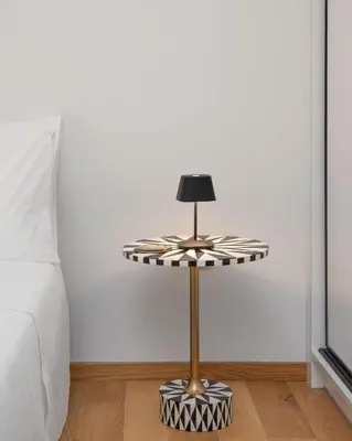 a table with a lamp on a floor next to a bed at Athens Riviera Penthouse in Athens