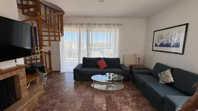 a living room with a couch and a table at Amazing villa with a magic view to the Aegean in Dhaskalión