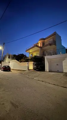 a house with a white fence in front of a street at Amazing villa with a magic view to the Aegean in Dhaskalión