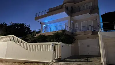a white house with a white fence and a gate at Amazing villa with a magic view to the Aegean in Dhaskalión
