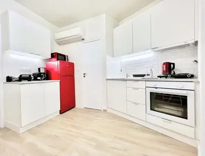 a kitchen with a red refrigerator and white cabinets at Minimal luxury 5BDR apt w/terrace AcropolisView in Athens