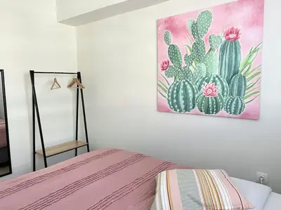 a bedroom with a bed and a painting of cactus at Minimal luxury 5BDR apt w/terrace AcropolisView in Athens