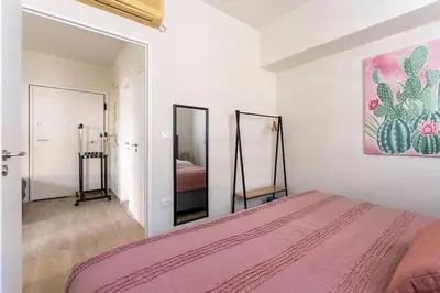 a bedroom with a pink bed and a mirror at Minimal luxury 5BDR apt w/terrace AcropolisView in Athens