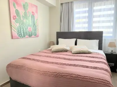 a bedroom with a large bed with a pink blanket at Minimal luxury 5BDR apt w/terrace AcropolisView in Athens