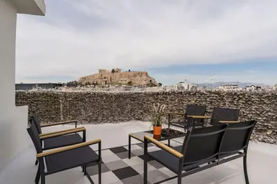 a group of chairs and a table and a building at Minimal luxury 5BDR apt w/terrace AcropolisView in Athens