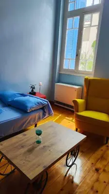 a room with a bed and a table and a chair at Yellow and blue relax house in Piraeus