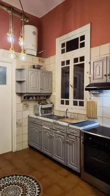 a kitchen with white cabinets and a sink and a stove at Yellow and blue relax house in Piraeus