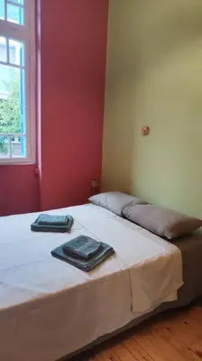 a bedroom with a bed with two towels on it at Yellow and blue relax house in Piraeus
