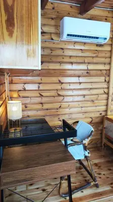 a desk and a chair in a room with wooden walls at Yellow and blue relax house in Piraeus