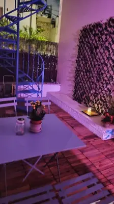 a room with two tables and a purple wall at Yellow and blue relax house in Piraeus