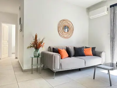 a living room with a gray couch with orange pillows at P&P Boutique Apartments in Athens