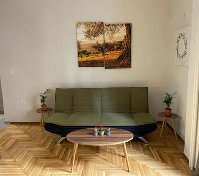 a living room with a green couch and a table at Nike’s Katechaki in Athens