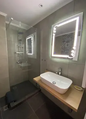 a bathroom with a sink and a shower with a mirror at Nike’s Katechaki in Athens