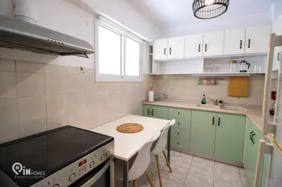 a kitchen with green cabinets and a stove top oven at Athenian Sky View - next to Metro in Athens