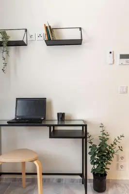 a black desk with a laptop on a white wall at Mooeve Exarchia in Athens