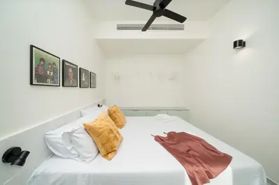 a bedroom with a white bed with a ceiling fan at Mooeve Exarchia in Athens
