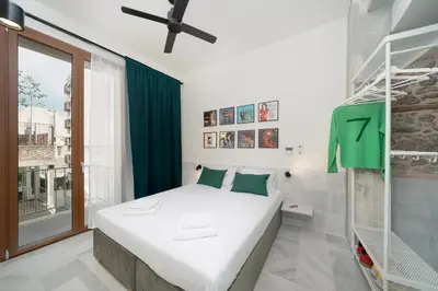 a bedroom with a white bed and a green curtain at Mooeve Exarchia in Athens