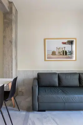 a living room with a blue couch and a table at Mooeve Exarchia in Athens