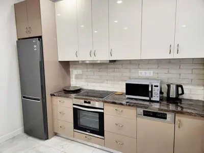 a kitchen with white cabinets and a black refrigerator at Kallithea's Luxury Apartment VIPGreece in Athens