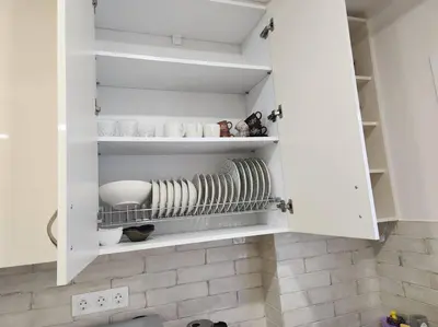 a white cupboard with plates and dishes in it at Kallithea's Luxury Apartment VIPGreece in Athens