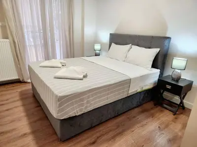 a bedroom with a large bed with two towels on it at Kallithea's Luxury Apartment VIPGreece in Athens