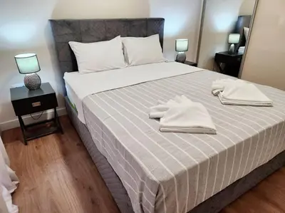 a bedroom with a large bed with two towels on it at Kallithea's Luxury Apartment VIPGreece in Athens