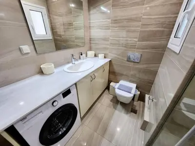 a bathroom with a washing machine and a sink at Kallithea's Luxury Apartment VIPGreece in Athens