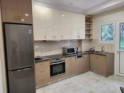 a kitchen with white cabinets and a stainless steel refrigerator at Kallithea's Luxury Apartment VIPGreece in Athens