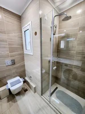 a bathroom with a glass shower and a toilet at Kallithea's Luxury Apartment VIPGreece in Athens