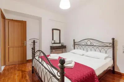 a bedroom with a bed with a red blanket and a mirror at Cozy 2 bedroom apartment in Piraeus in Piraeus