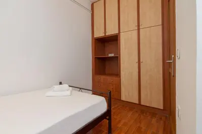 a bedroom with a bed and a wooden cabinet at Cozy 2 bedroom apartment in Piraeus in Piraeus