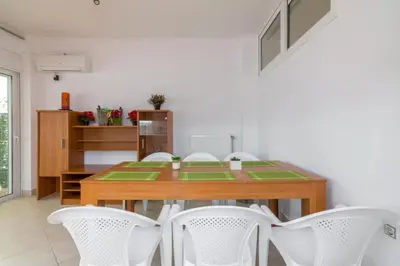 a dining room with a wooden table and white chairs at Cozy 2 bedroom apartment in Piraeus in Piraeus