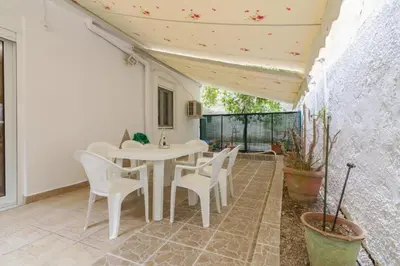 a white table and chairs on a patio at Cozy 2 bedroom apartment in Piraeus in Piraeus