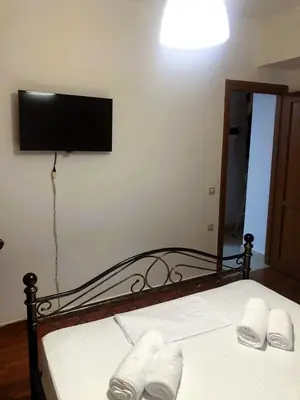 a bedroom with a bed with a television on the wall at Cozy 2 bedroom apartment in Piraeus in Piraeus