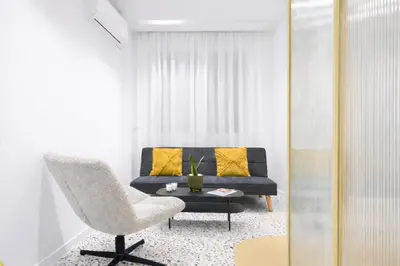 a living room with a couch and a chair at Nueva era @ Athens heart , Romvis apartments in Athens