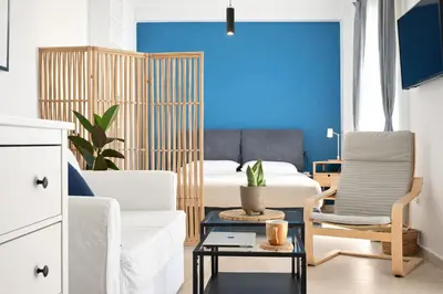 a bedroom with a bed and a chair and a table at Nueva era @ Athens heart , Romvis apartments in Athens