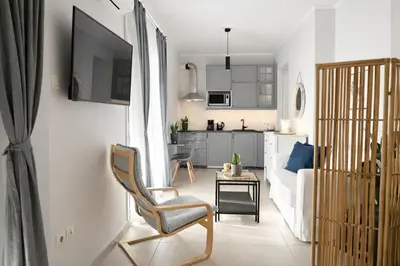 a living room with a couch and a chair and a table at Nueva era @ Athens heart , Romvis apartments in Athens